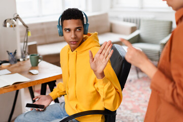 Man with headphones gesturing while at office desk