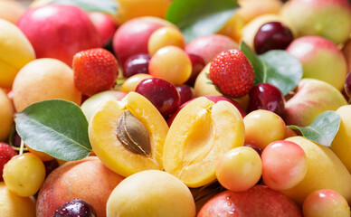 Mix of fresh fruits with leaves as background