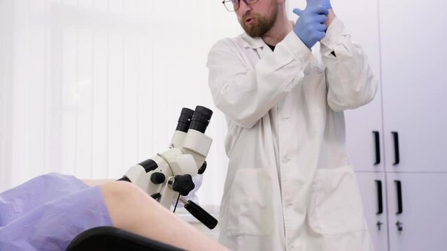Gynecological office in the clinic. A gynecologist uses a colposcope to examine a patient. A woman lies on a gynecological chair during a colposcopy. Preparing for pregnancy. Modern hospital.