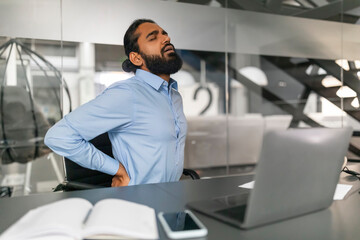 Businessman with hands behind head looking away