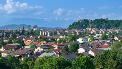 AERIAL: A panoramic cityscape of Ljubljana against the scenic alpine backdrop. - obrazy, fototapety, plakaty