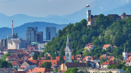 AERIAL: Panoramic vista of the Ljubljana cityscape with mountains in background