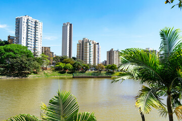 Residential buildings on the edge of a lake with many trees. Blue sky with clouds. City of Belo...