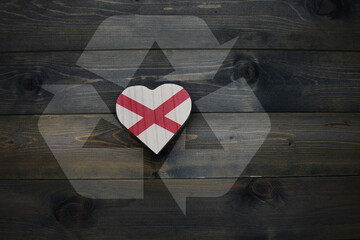 wooden heart with national flag of alabama state near reduce, reuse and recycle sing on the wooden...