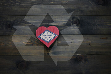 wooden heart with national flag of arkansas state near reduce, reuse and recycle sing on the wooden...