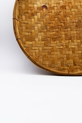 Threshing basket with white background. A traditional circular weaving object for household use and...