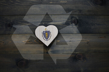 wooden heart with national flag of massachusetts state near reduce, reuse and recycle sing on the...