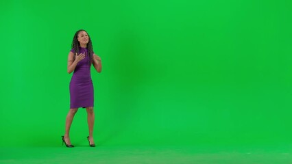 Female in dress isolated on chroma key green screen background. Full shot african american woman tv news host standing talking looking at camera.