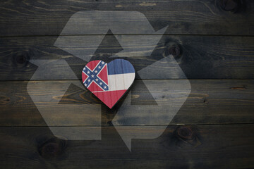 wooden heart with national flag of mississippi state near reduce, reuse and recycle sing on the...