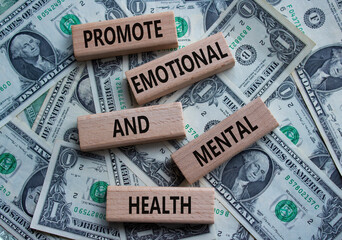 Health symbol. Wooden blocks with words Promote Emotional and Mental Health. Beautiful dollar...