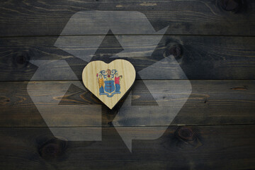 wooden heart with national flag of new jersey state near reduce, reuse and recycle sing on the...