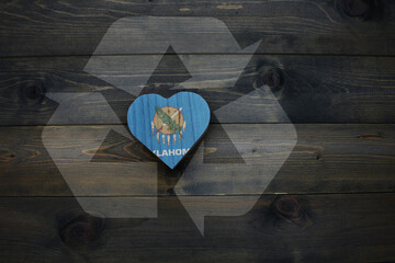 wooden heart with national flag of oklahoma state near reduce, reuse and recycle sing on the wooden...