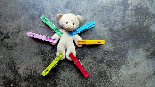 White Voodoo doll with both hand and legs clipped with colorful clips. Black magic concept.