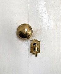 Antique door lock. Golden door handle with antique gold-engraved crest. Ancient lock with key. Old metal key in the keyhole.