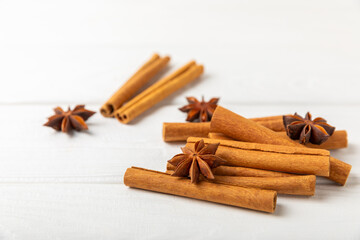 Cinnamon sticks and anise on a textured background. Cinnamon roll and star anise. Spicy spice for baking, desserts and drinks. Fragrant ground cinnamon.Place for text. copy space.