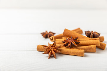 Cinnamon sticks and anise on a textured background. Cinnamon roll and star anise. Spicy spice for baking, desserts and drinks. Fragrant ground cinnamon.Place for text. copy space.