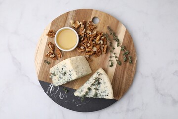 Obraz na płótnie Canvas Tasty blue cheese with thyme, honey and walnuts on white marble table, top view