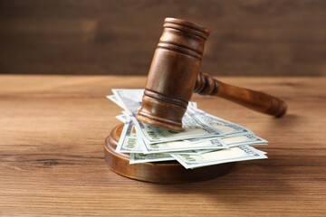 Judge's gavel and money on wooden table. Space for text