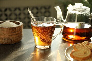 Tasty tea and sugar on dark table, closeup