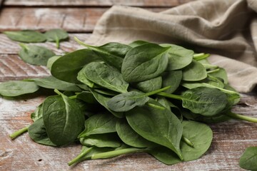 Pile of fresh spinach leaves on wooden rustic table, closeup