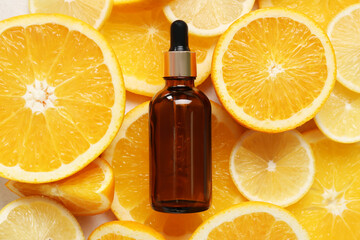 Bottle of vitamin C on citrus fruits slices background
