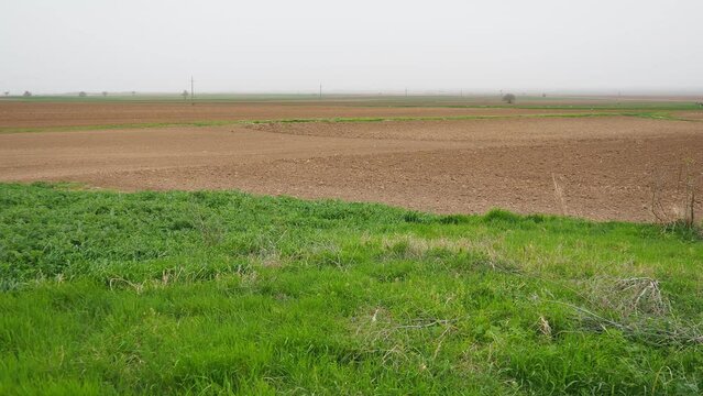 A tractor-plowed field in Chalma, Serbia. Agribusiness. Agricultural land. Fertile black soil. Row of furrows in a plowed field prepared for planting crops in the spring. Horizontal perspective view.
