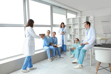 Female doctor bringing coffee to her colleagues in clinic