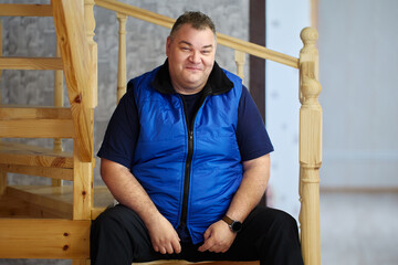 Problems with excess weight after 40 years, tall Caucasian man, 47 years old, sits on steps of...