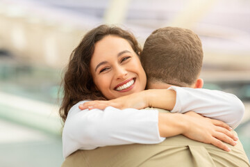 Close-up of woman smiling hugging her partner