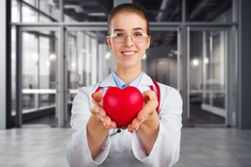 Hands of cardiologist doctor hold red heart