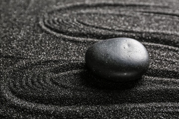 Fototapeta na wymiar Spa stone on black sand with lines, closeup. Zen concept