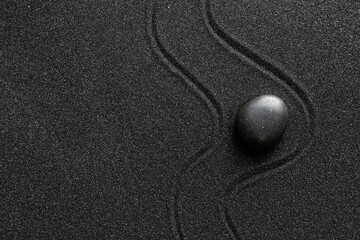 Spa stone on black sand with lines. Zen concept