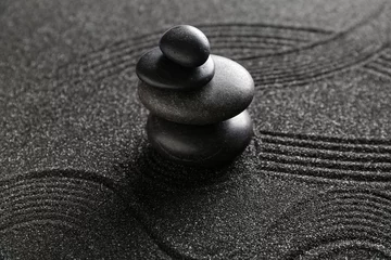 Outdoor kussens Spa stones on black sand with lines, closeup. Zen concept © Pixel-Shot