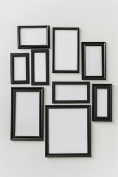 A group of black picture frames on a white wall. Perfect for interior design concepts
