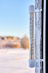 16 degrees below zero Celsius on an outdoor thermometer mounted on wooden window frame. - obrazy, fototapety, plakaty