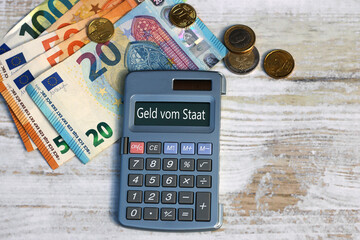 Euroscheine und Taschenrechner mit dem Text Geld vom Staat. - obrazy, fototapety, plakaty