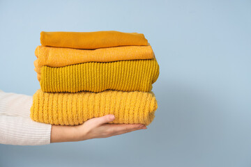 Woman with yellow sweaters on light background