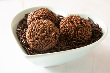 Chocolate truffle balls Brigadeiro brazilian candy and chocolate flakes front view clean background