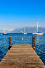 Fototapeta na wymiar Wooden pier overlooking the Alps and Lake Geneva in Switzerland