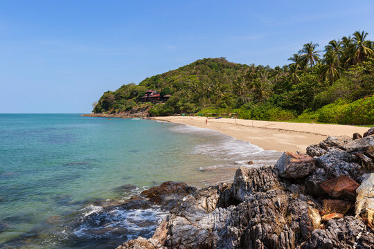 Few people at the idyllic Nui Beach in Koh Lanta, Thailand, on a sunny day. Beautiful tropical landscape with lush nature and turquoise water.