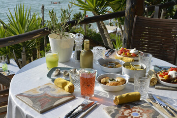 cocktail servito con un abbondante aperitivo servito in un bar in riva al mare - 773476337