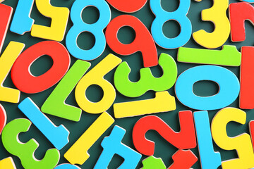 Colorful numbers on green background, top view