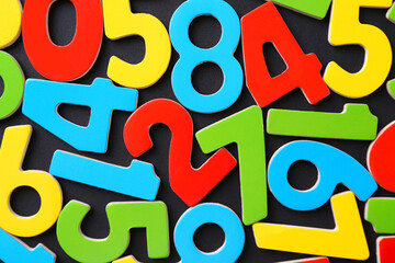 Colorful numbers on black background, top view