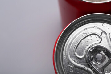 Energy drinks in wet cans on grey background, top view. Space for text