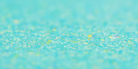 Green background with a thin focal part and a main part in defocus. Macro photo of glitter paper.