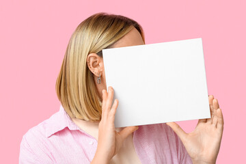Woman with multiple ear piercing and blank paper sheet on pink background - obrazy, fototapety, plakaty