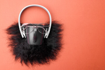 Man's face made of artificial beard, headphones and glasses on terracotta background, top view....