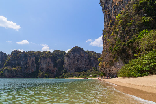 Scenic view of the Tonsai Beach and high limestone karst cliffs in Railay, Krabi, Thailand, on a sunny day.