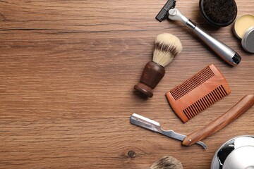 Moustache and beard styling tools on wooden background, flat lay. Space for text