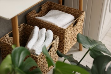 Storage baskets with folded white towels indoors